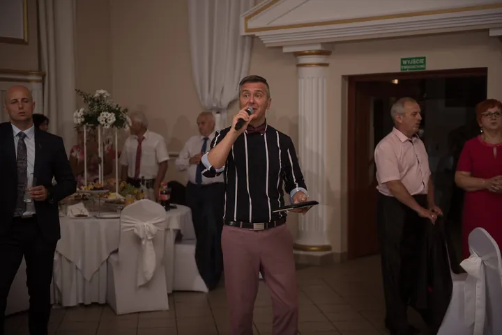 Wokalista Maxis śpiewa wśród gości przy stołach weselnych