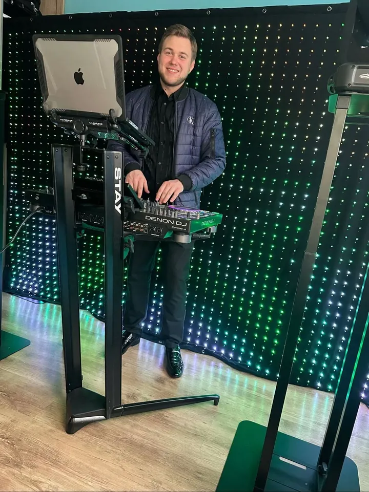 Maxis DJ przy konsolecie na tle kurtyny LED
